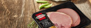 Pressure Sensitive Hormel smoked pork chops on wood table with peas and garnish